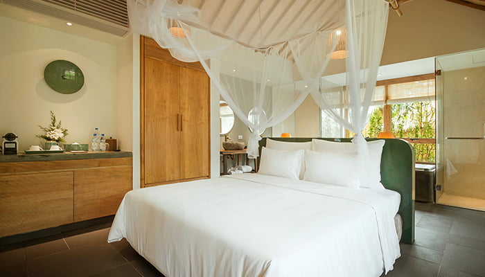 Wellness bungalow bedroom with canopy bed at Alba Wellness Valley Hue